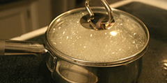 Water boils in a pot, lid rumbles sound , 2 sounds
